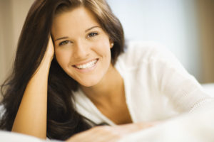 Smiling woman resting cheek on hand